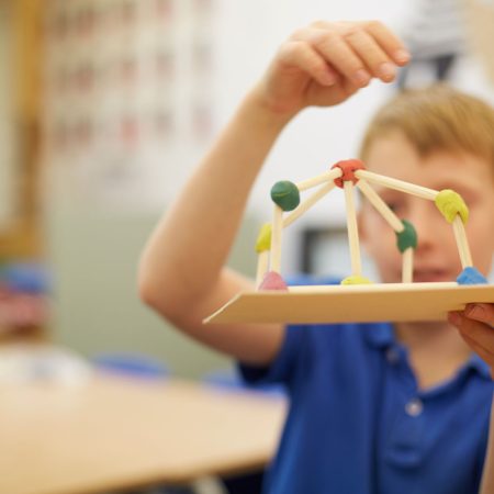 schoolboy-making-ball-and-stick-model-in-classroom-2025-04-03-05-04-10-utc